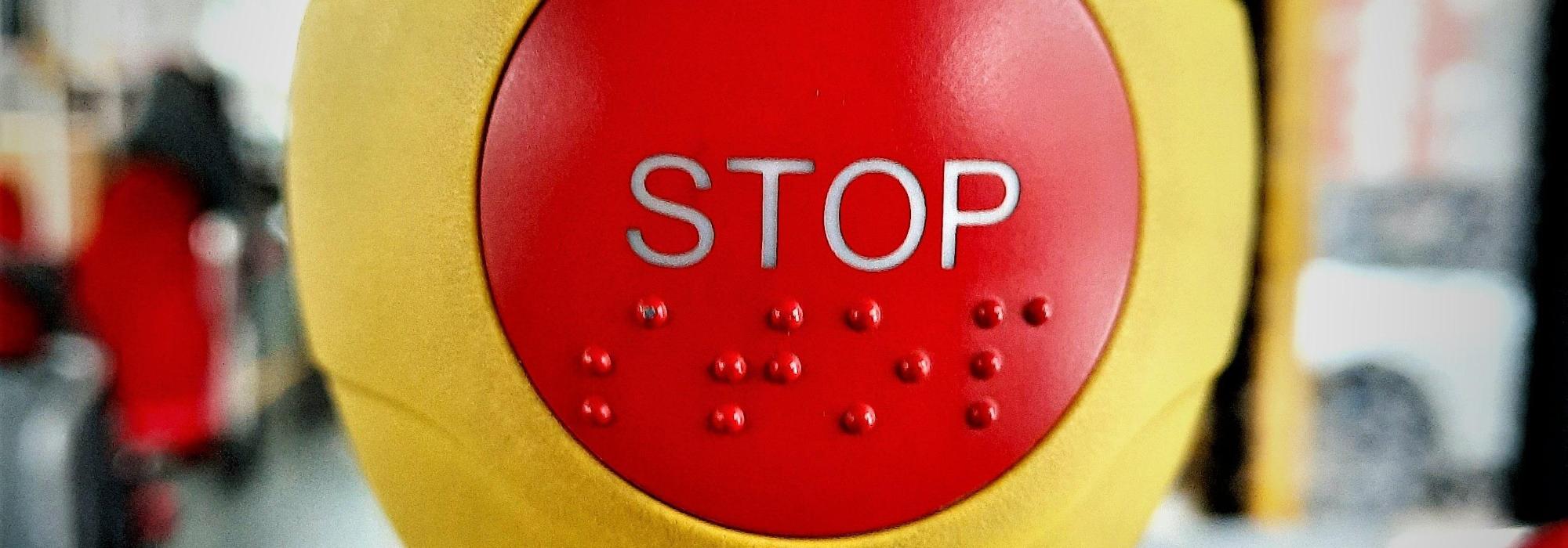 Symbolbild Stop/Halt: Roter Knopf im Bus Hochformat